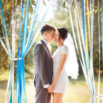 Жених и невеста на свадебной фотосессии в Минске на фоне декора из цветных лент