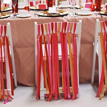 Украшение свадебных стульев в Минске яркими лентами в розово-оранжевых оттенках