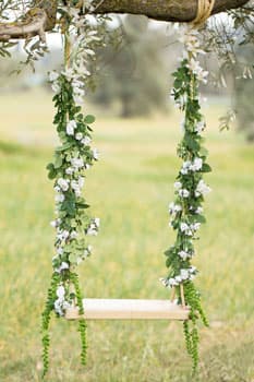 Декоративные свадебные качели с цветами на природе в Минске