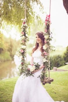 Невеста на украшенных цветами свадебных качелях на фотосессии в Минске