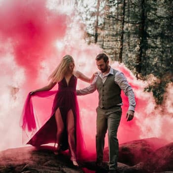 Пара на свадебной фотосессии в Минске в лесу на фоне розового дымового фонтана