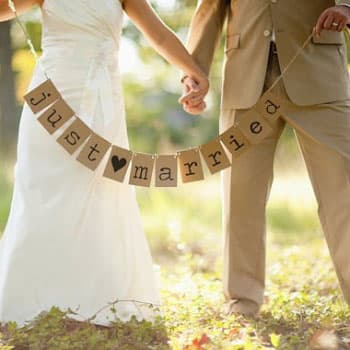 Молодожёны на свадебной фотосессии в Минске держат гирлянду с надписью Just Married