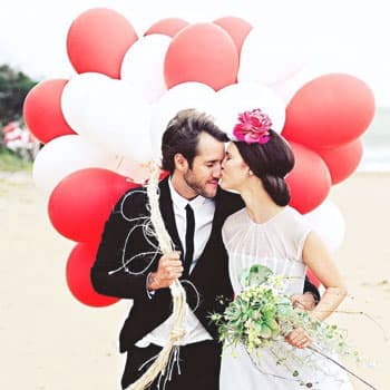 Молодожёны на свадебной фотосессии в Минске на пляже с красно-белыми воздушными шарами