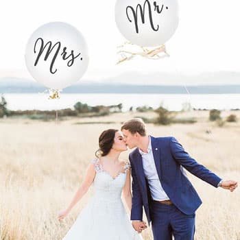 Жених и невеста на свадебной фотосессии в Минске с шарами Mr. и Mrs. на фоне природы