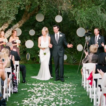 Выход молодожёнов после церемонии на свадебной фотосессии в Минске на фоне украшений из подвесных кругов