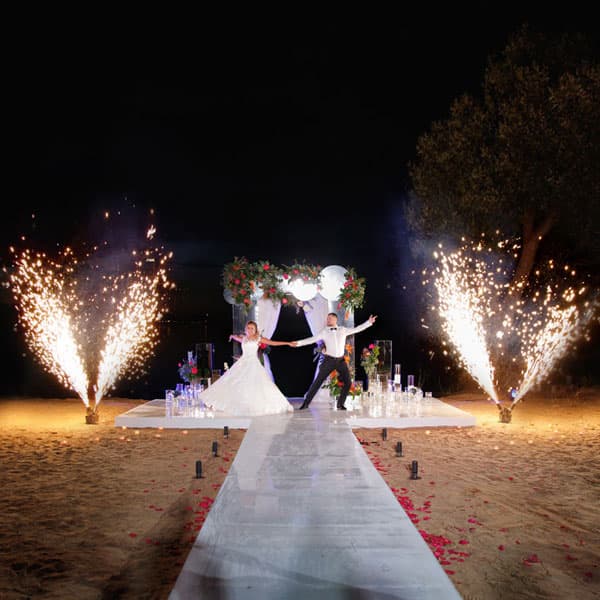 Эффектный свадебный выход молодожёнов с фонтанами холодных огней на пляжной церемонии в Минске