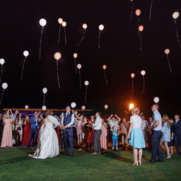 Молодожёны и гости запускают воздушные шары в ночное небо на свадьбе в Минске