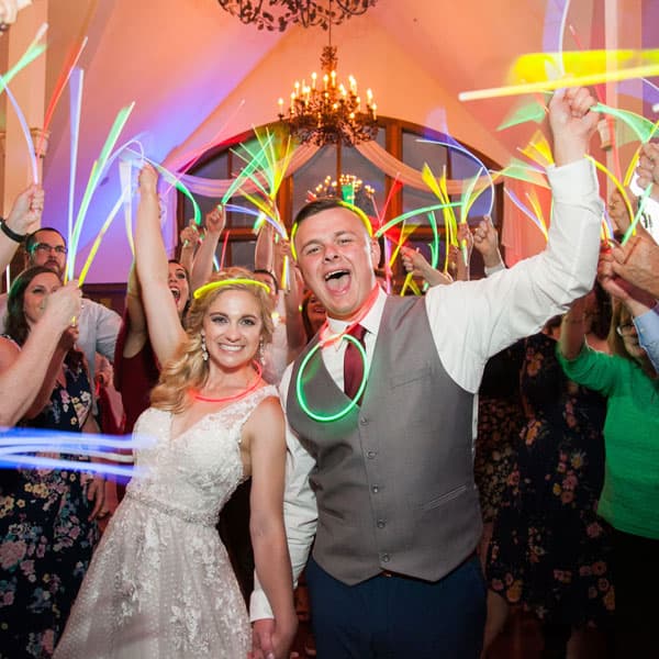 Весёлый свадебный финал с молодожёнами и гостями, держащими разноцветные неоновые палочки в Минске